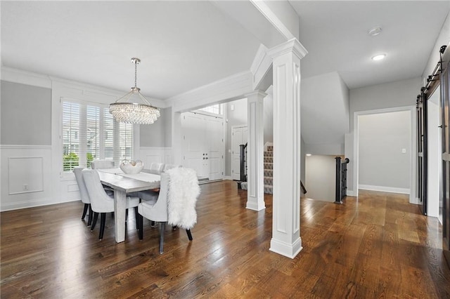 8833 N Crescent Ave, Kansas City, MO 64157 - dining space featuring a barn door, a chandelier, decorative columns, wainscoting, and a decorative wall