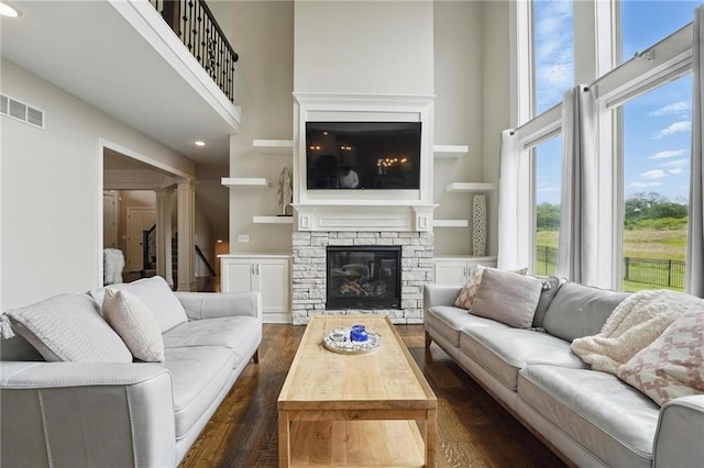 8833 N Crescent Ave, Kansas City, MO 64157 - living room with a high ceiling, a stone fireplace, dark wood finished floors, and recessed lighting