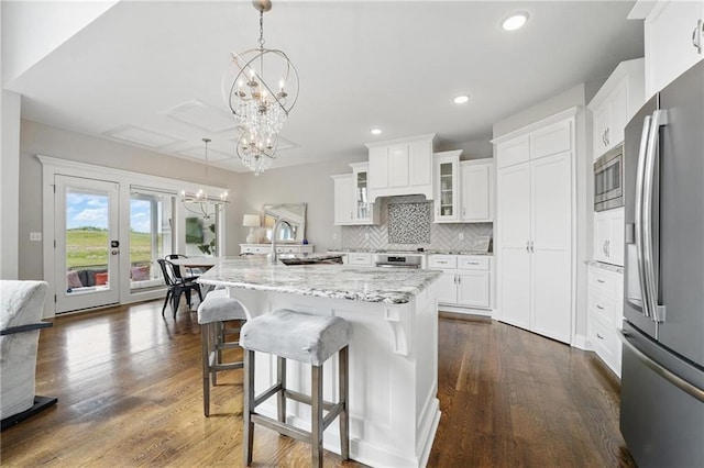 8833 N Crescent Ave, Kansas City, MO 64157 - kitchen featuring appliances with stainless steel finishes, a chandelier, glass insert cabinets, a sink, and decorative backsplash