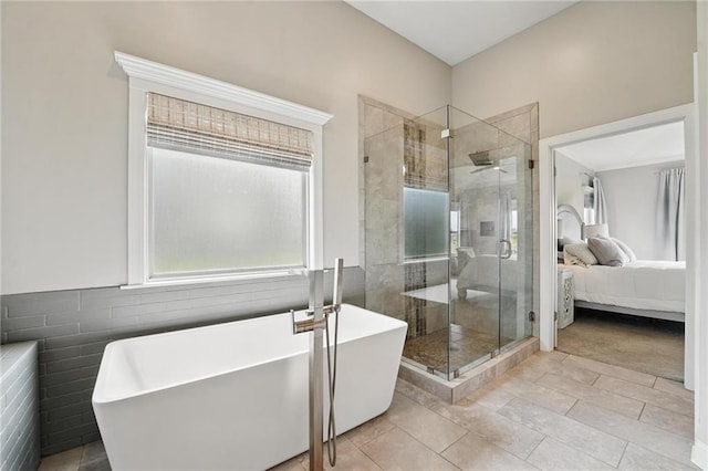 8833 N Crescent Ave, Kansas City, MO 64157 - ensuite bathroom featuring healthy amount of natural light, a shower stall, a freestanding bath, and tile walls