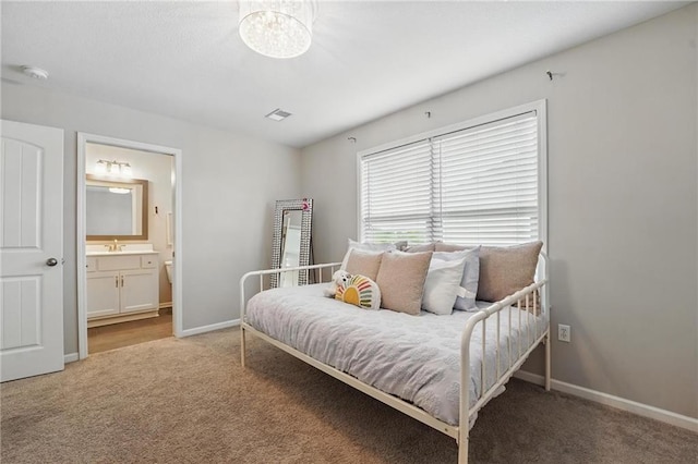 8833 N Crescent Ave, Kansas City, MO 64157 - bedroom featuring light colored carpet, baseboards, ensuite bath, a sink, and a chandelier