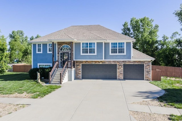 2251 Valley View Dr, Tonganoxie, KS 66086 - raised ranch with concrete driveway, an attached garage, and stone siding