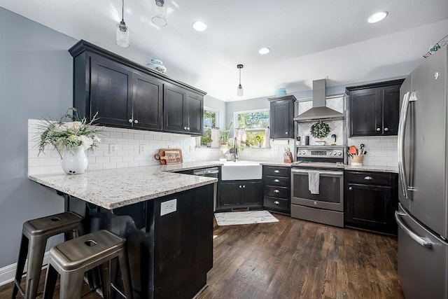 2251 Valley View Dr, Tonganoxie, KS 66086 - kitchen featuring appliances with stainless steel finishes, wall chimney exhaust hood, a peninsula, a sink, and decorative backsplash