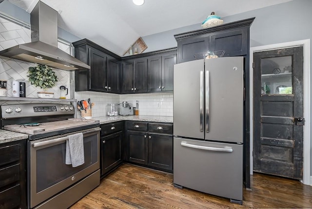 2251 Valley View Dr, Tonganoxie, KS 66086 - kitchen with stainless steel appliances, wall chimney range hood, light stone counters, vaulted ceiling, and dark wood-type flooring