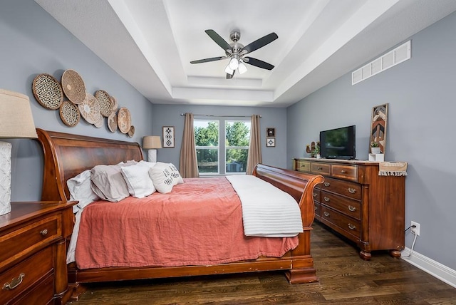 2251 Valley View Dr, Tonganoxie, KS 66086 - bedroom featuring dark wood-style floors, a tray ceiling, baseboards, and a ceiling fan