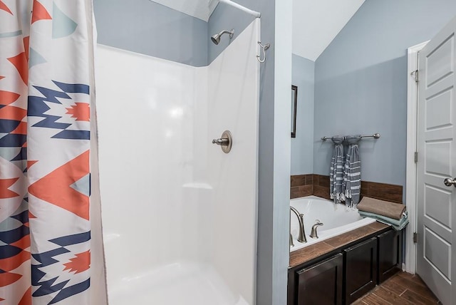 2251 Valley View Dr, Tonganoxie, KS 66086 - bathroom featuring a stall shower, wood finished floors, vaulted ceiling, and a garden tub
