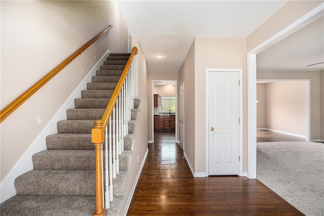 staircase with baseboards and wood finished floors