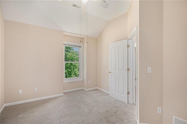 carpeted empty room with vaulted ceiling, baseboards, and ceiling fan