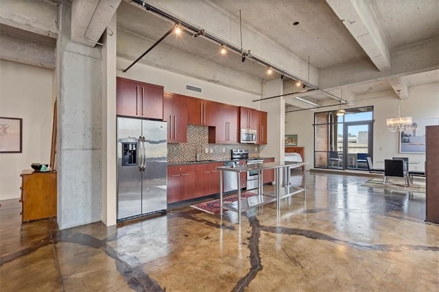 360 W Pershing Rd Unit 210, Kansas City, MO 64108 - kitchen with appliances with stainless steel finishes, finished concrete floors, tasteful backsplash, dark brown cabinets, and open floor plan
