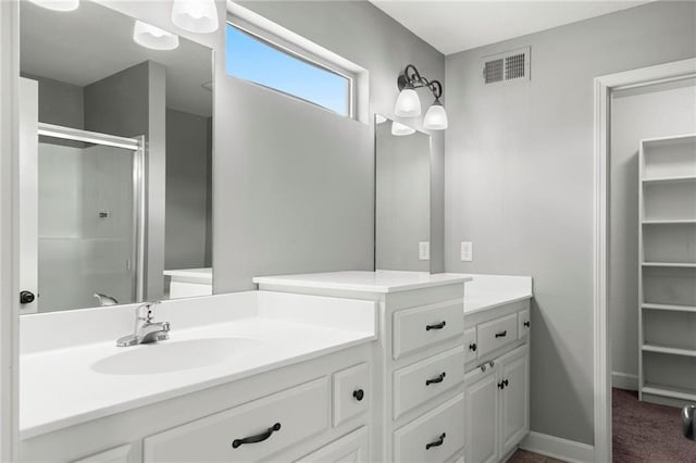 full bath featuring a shower stall, vanity, and baseboards