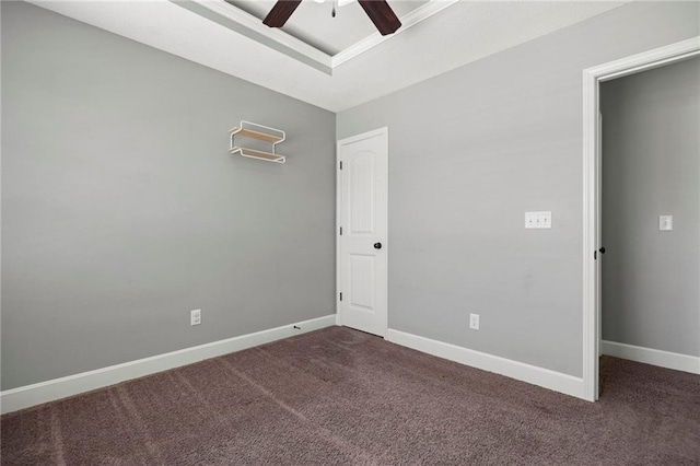 carpeted spare room with ceiling fan, baseboards, and a tray ceiling
