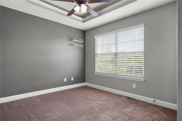 unfurnished room with ceiling fan, carpet flooring, a raised ceiling, and baseboards