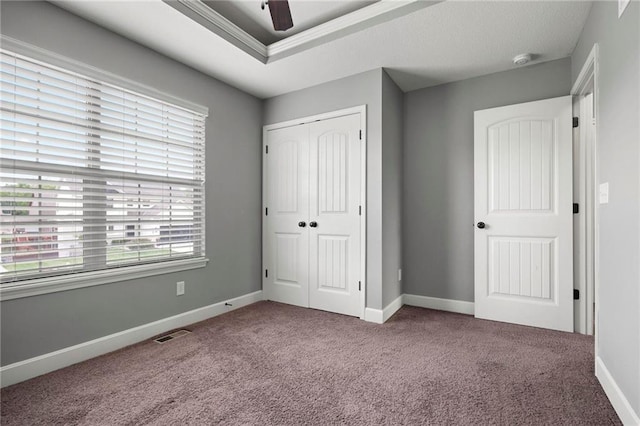 unfurnished bedroom with carpet floors, a closet, baseboards, and ceiling fan