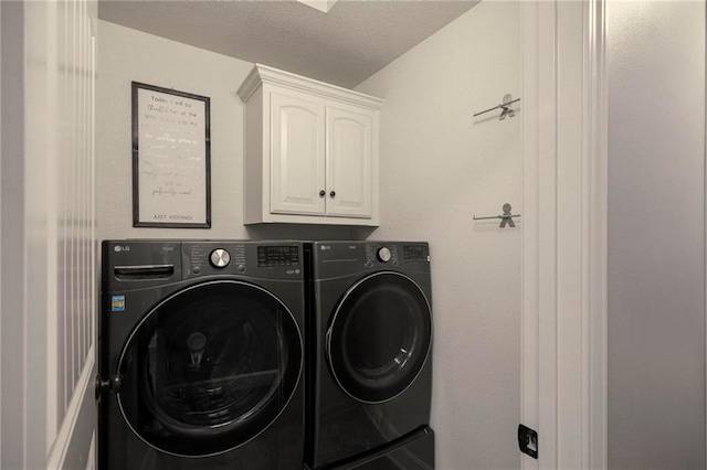 clothes washing area featuring washing machine and dryer and cabinet space