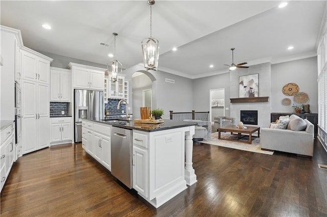 16609 Cody St, Overland Park, KS 66221 - kitchen featuring stainless steel appliances, a ceiling fan, a kitchen island with sink, recessed lighting, and arched walkways