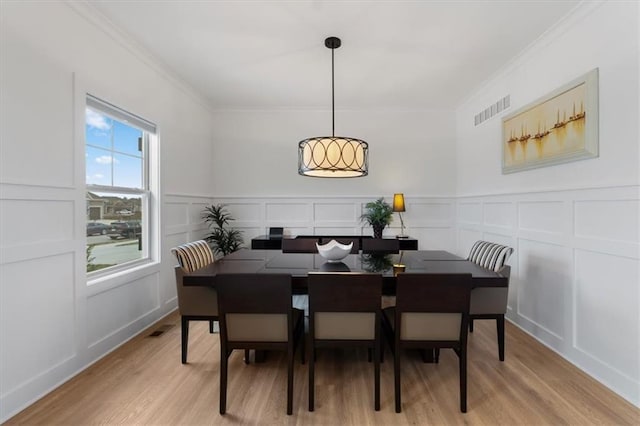 16521 S Stagecoach St, Olathe, KS 66062 - dining space with a decorative wall, ornamental molding, light wood finished floors, and a wainscoted wall