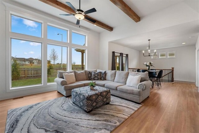 16521 S Stagecoach St, Olathe, KS 66062 - living room with a chandelier, light wood finished floors, beamed ceiling, and ceiling fan