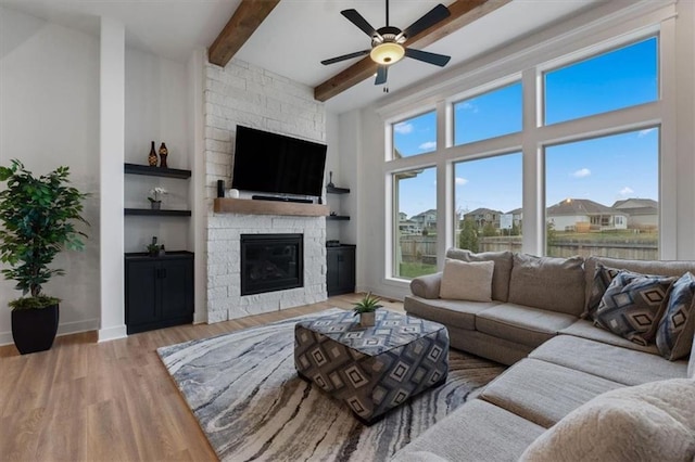 16521 S Stagecoach St, Olathe, KS 66062 - living room with plenty of natural light, ceiling fan, a stone fireplace, wood finished floors, and beam ceiling