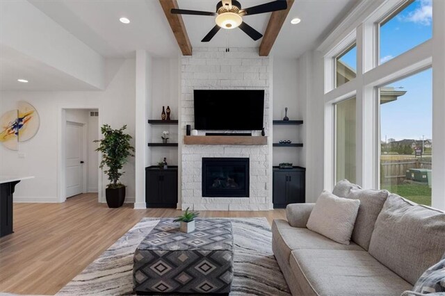 16521 S Stagecoach St, Olathe, KS 66062 - living room with a fireplace, healthy amount of natural light, a ceiling fan, beam ceiling, and light wood finished floors