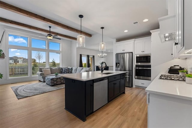 16521 S Stagecoach St, Olathe, KS 66062 - kitchen featuring stainless steel appliances, a sink, light countertops, dark cabinets, and white cabinets