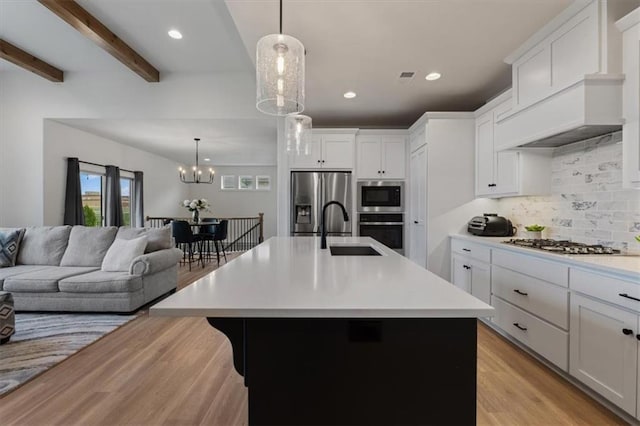 16521 S Stagecoach St, Olathe, KS 66062 - kitchen with a sink, stainless steel appliances, light wood-style floors, light countertops, and open floor plan