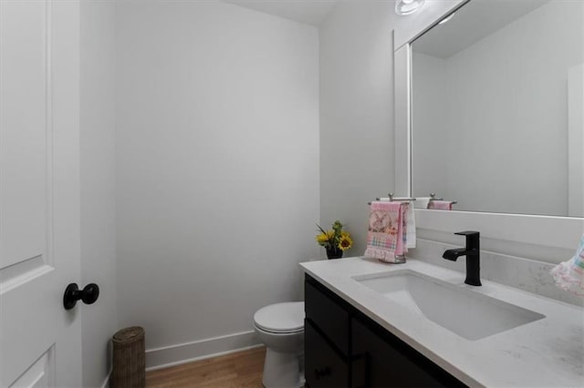 16521 S Stagecoach St, Olathe, KS 66062 - bathroom featuring wood finished floors, vanity, toilet, and baseboards