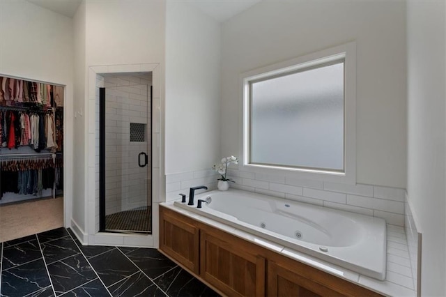 16521 S Stagecoach St, Olathe, KS 66062 - bathroom with marble look tiles, a shower stall, a tub with jets, and a walk in closet