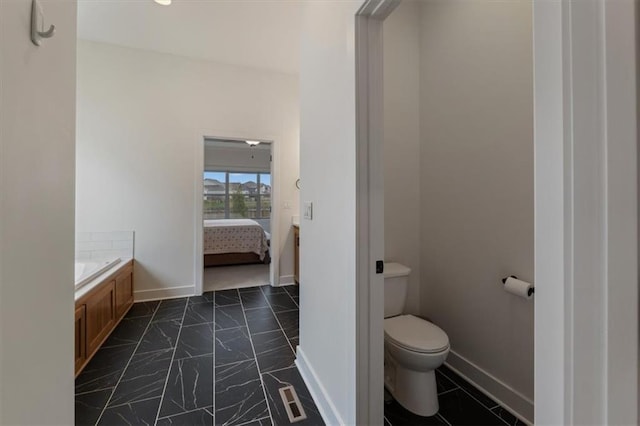 16521 S Stagecoach St, Olathe, KS 66062 - ensuite bathroom with toilet, baseboards, and a tub