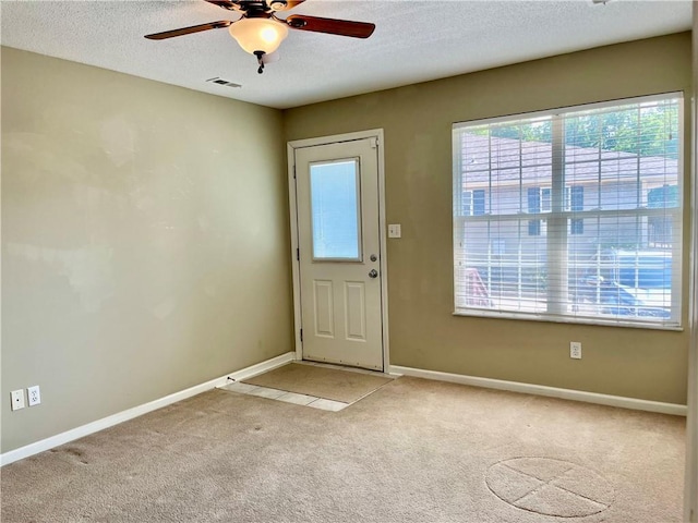 entrance foyer with light colored carpet, ceiling fan, a textured ceiling, and baseboards
