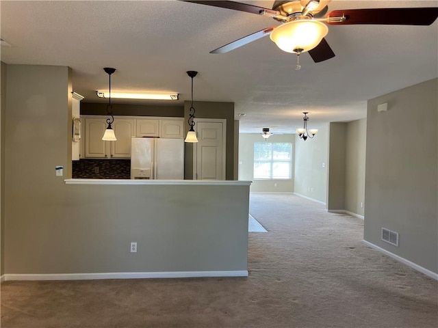 kitchen with white fridge with ice dispenser, light carpet, a ceiling fan, decorative light fixtures, and baseboards