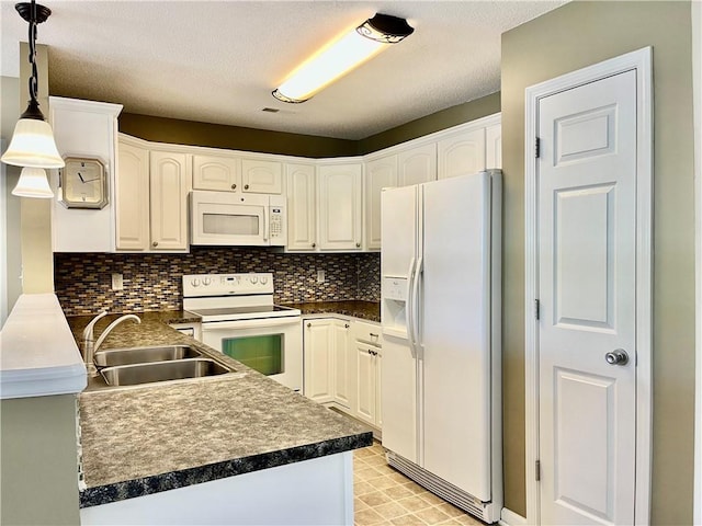 kitchen with white appliances, a sink, dark countertops, tasteful backsplash, and decorative light fixtures