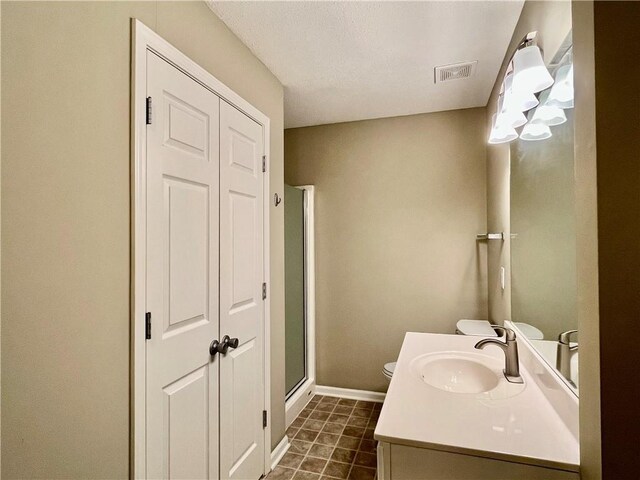 full bath featuring toilet, vanity, a stall shower, and baseboards