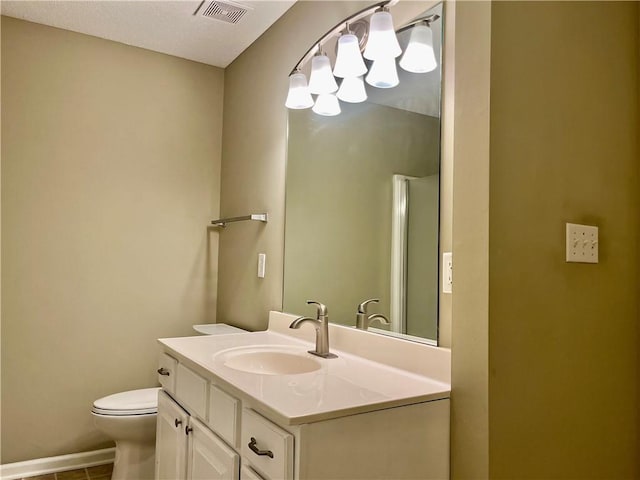 bathroom featuring toilet, vanity, a chandelier, and tile patterned flooring
