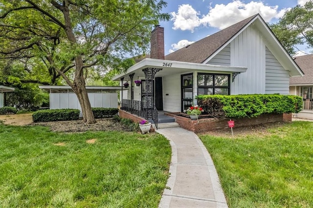 2647 Minnesota Ave, Kansas City, KS 66102 - view of front of home with a front lawn, roof with shingles, and board and batten siding