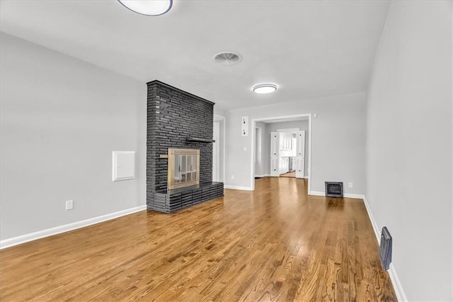 2647 Minnesota Ave, Kansas City, KS 66102 - unfurnished living room featuring wood finished floors, a fireplace, and baseboards