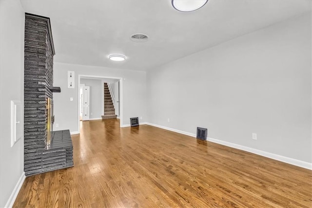 2647 Minnesota Ave, Kansas City, KS 66102 - unfurnished living room featuring stairs, wood finished floors, and baseboards