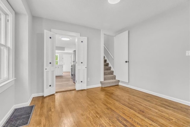 2647 Minnesota Ave, Kansas City, KS 66102 - unfurnished room featuring stairs, light wood-type flooring, and baseboards