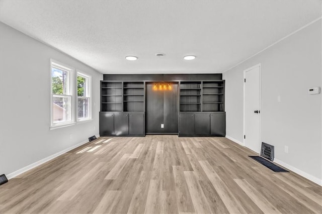 2647 Minnesota Ave, Kansas City, KS 66102 - unfurnished bedroom with light wood-type flooring, baseboards, and a textured ceiling