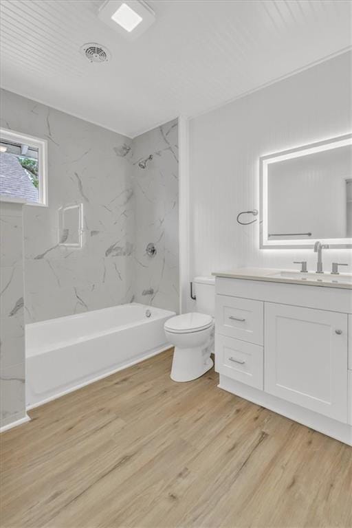 2647 Minnesota Ave, Kansas City, KS 66102 - full bath featuring vanity, toilet, wood finished floors, and bathing tub / shower combination