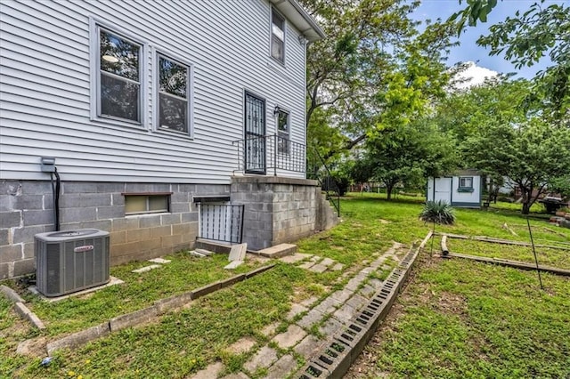 2647 Minnesota Ave, Kansas City, KS 66102 - view of side of home with central AC, an outbuilding, a storage unit, and a yard