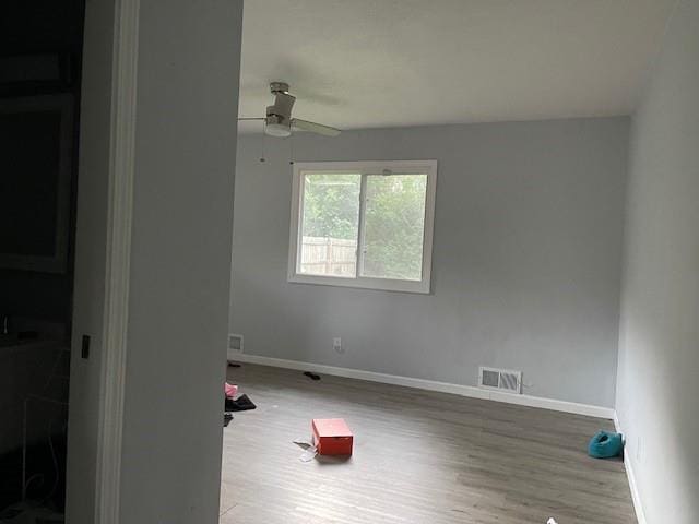 3602 Rowland Ave, Kansas City, KS 66104 - unfurnished room with wood finished floors, a ceiling fan, and baseboards