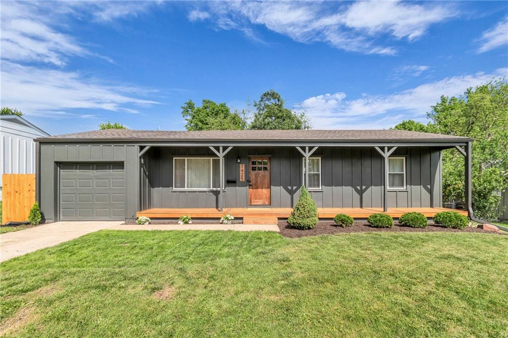 ranch-style house featuring a garage, a porch, driveway, and board and batten siding