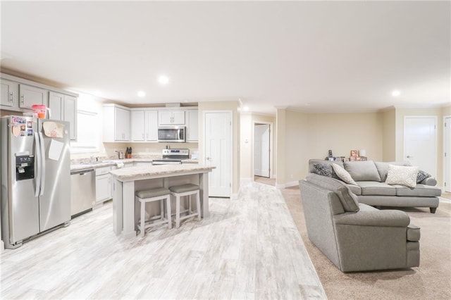 1365 NW 460th Rd, Holden, MO 64040 - kitchen with stainless steel appliances, crown molding, open floor plan, a kitchen island, and a kitchen bar