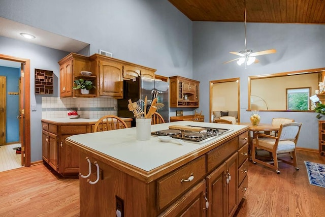 12808 Howe Dr, Leawood, KS 66209 - kitchen with stainless steel fridge with ice dispenser, high vaulted ceiling, electric cooktop, light wood-style flooring, and brown cabinets