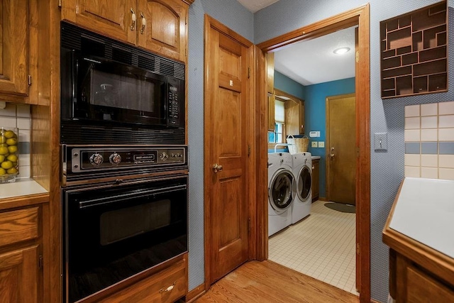 12808 Howe Dr, Leawood, KS 66209 - kitchen with black appliances, separate washer and dryer, brown cabinetry, and light countertops