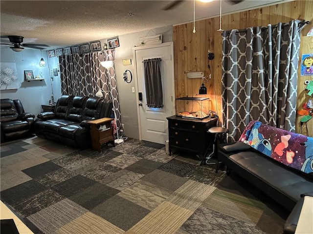 living area featuring a ceiling fan and a textured ceiling