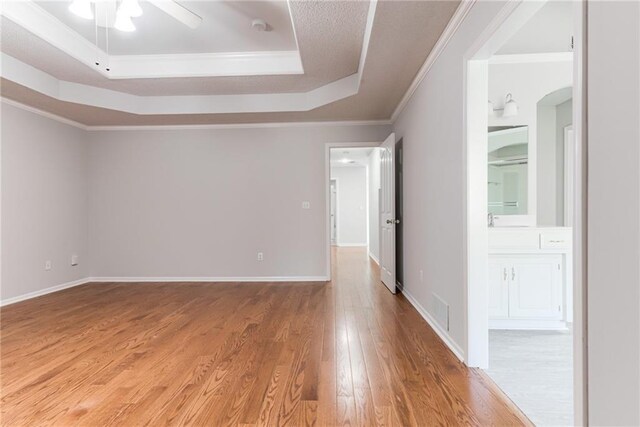 6402 W 147th Ter, Overland Park, KS 66223 - empty room featuring a tray ceiling, wood finished floors, ceiling fan, crown molding, and baseboards