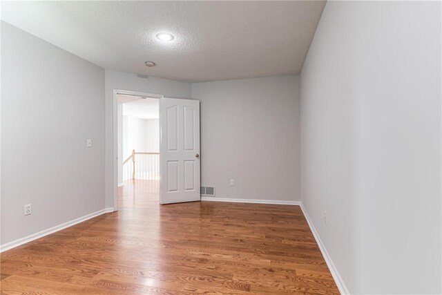 6402 W 147th Ter, Overland Park, KS 66223 - empty room featuring a textured ceiling, light wood-style floors, and baseboards