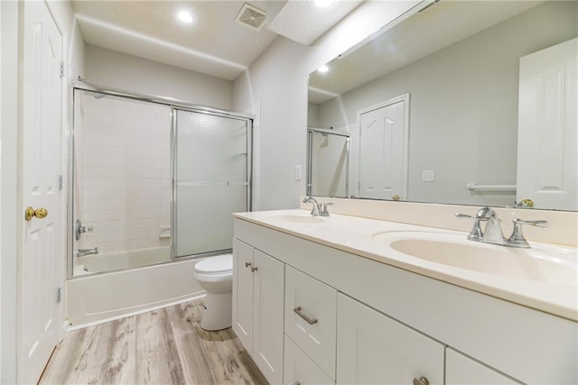6402 W 147th Ter, Overland Park, KS 66223 - full bath with wood finished floors, double vanity, toilet, enclosed tub / shower combo, and recessed lighting