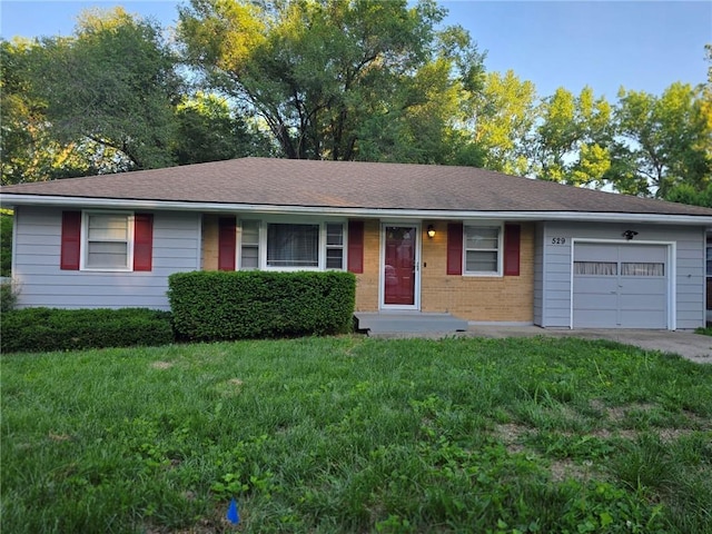 529 S Northern Blvd, Sugar Creek, MO 64054 - ranch-style home with a front lawn, an attached garage, brick siding, and a shingled roof
